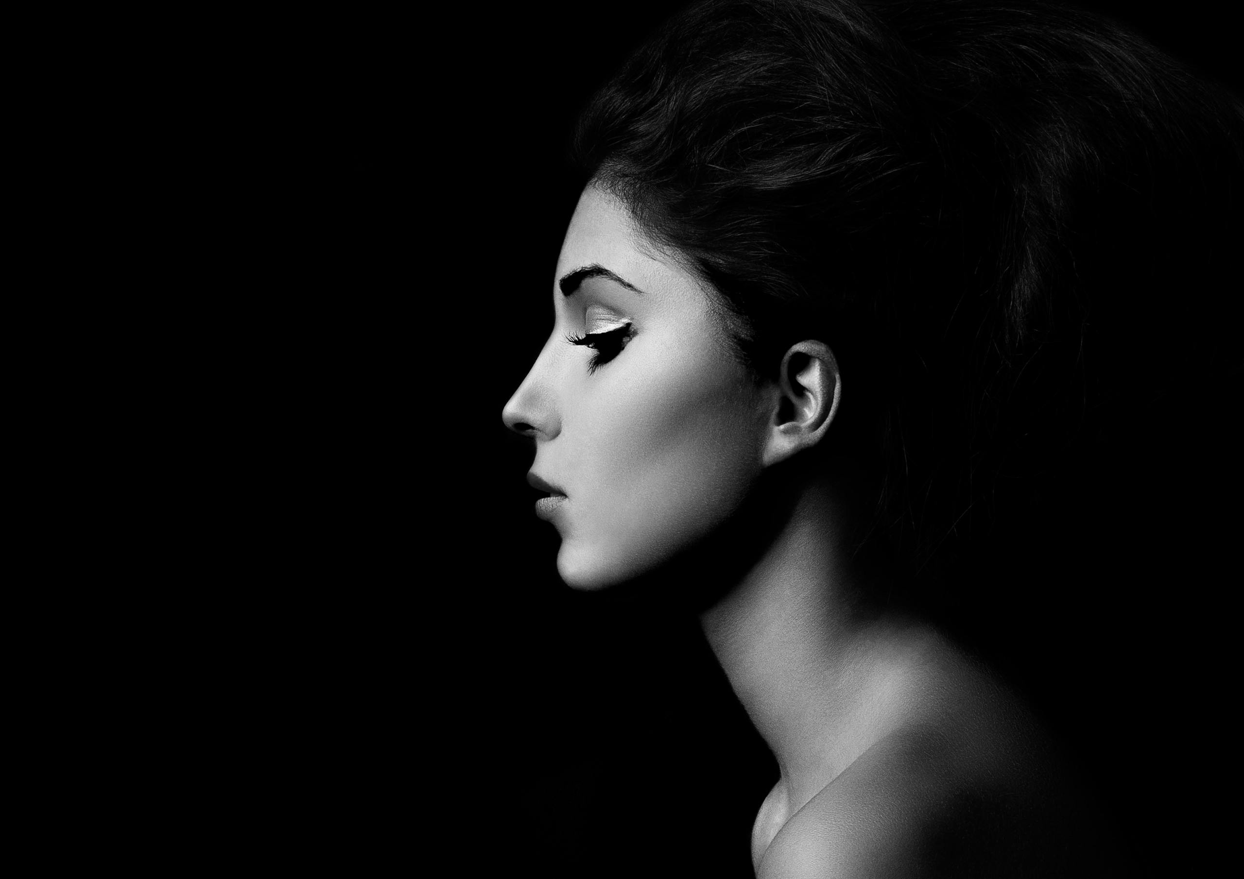 Artistic black and white side profile of a woman with bold makeup.