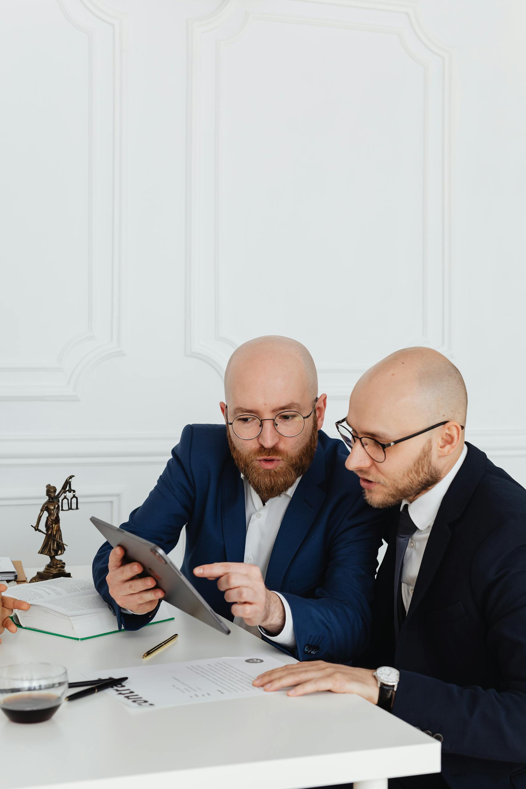 Two professionals discussing with a digital tablet during a business meeting in an office setting.